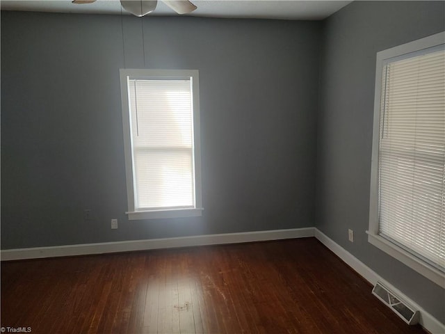 empty room with ceiling fan and dark hardwood / wood-style floors