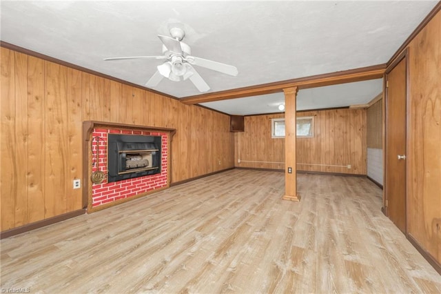 1788 Joshie Dr, Winston-Salem, NC 27103 - unfurnished living room with light wood-type flooring, wood walls, a fireplace, ceiling fan, and baseboards