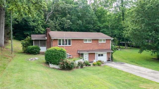 1788 Joshie Dr, Winston-Salem, NC 27103 - view of front of home featuring asphalt driveway, brick siding, a chimney, an attached garage, and a front yard