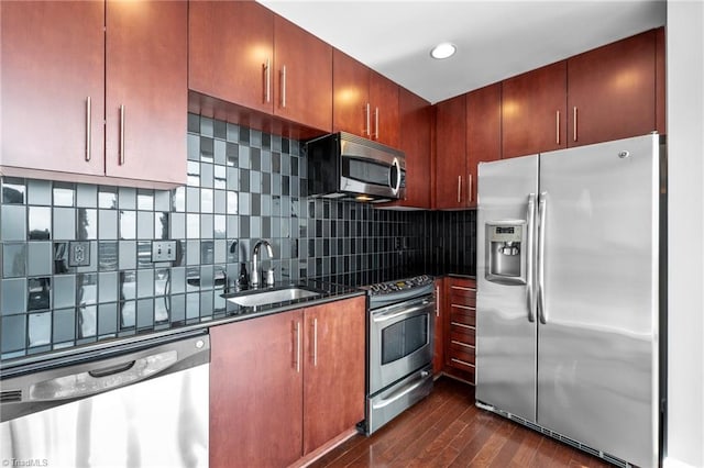 kitchen with tasteful backsplash, appliances with stainless steel finishes, dark wood-type flooring, and sink