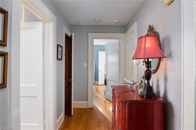 corridor with wood finished floors and baseboards