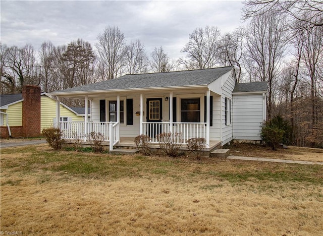 ranch-style home with a shingled roof, a front lawn, and a porch