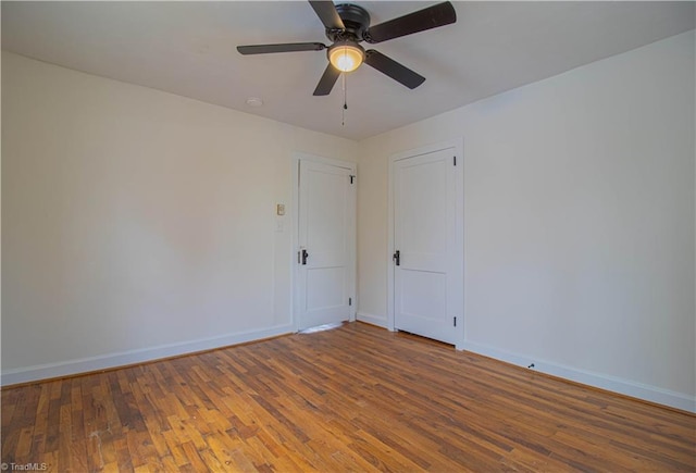 unfurnished room featuring a ceiling fan, baseboards, and wood finished floors