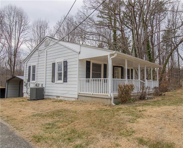 view of front of property with crawl space, cooling unit, a porch, a carport, and a front yard