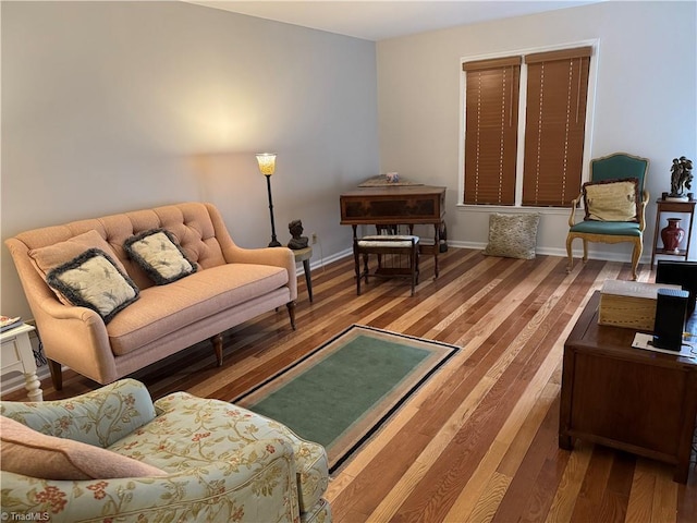 living area with baseboards and wood finished floors