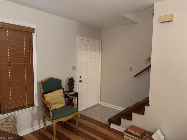 foyer entrance featuring baseboards, wood finished floors, and stairs