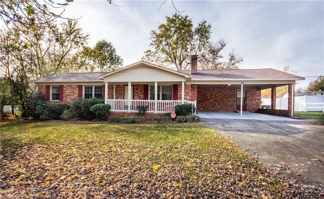 ranch-style home featuring a carport, a porch, and a front lawn