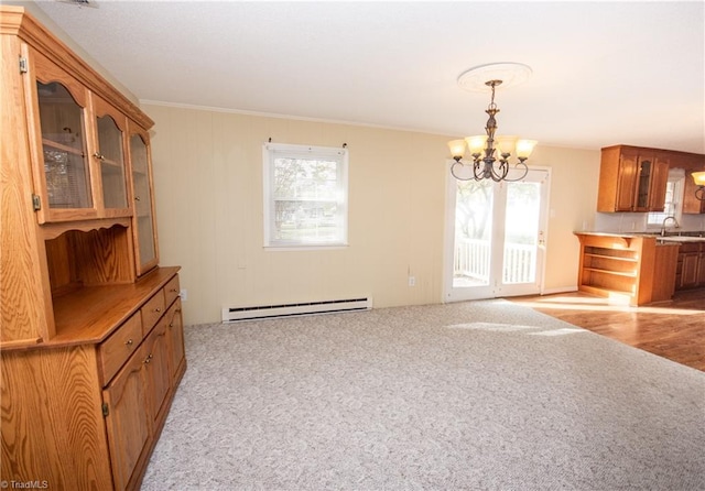 kitchen with a baseboard radiator, sink, a wealth of natural light, and a chandelier