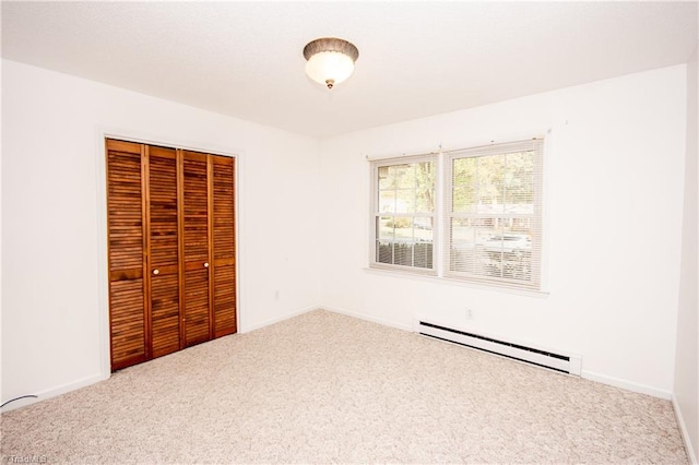 unfurnished bedroom featuring a baseboard radiator, a closet, and carpet