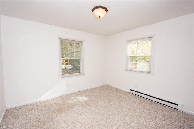 spare room featuring carpet floors and a baseboard radiator