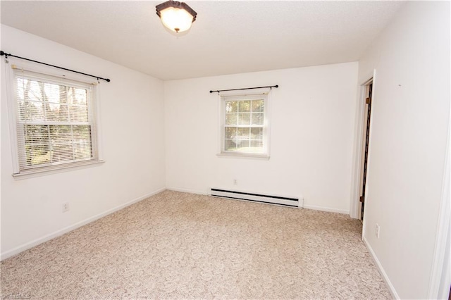 carpeted empty room featuring baseboard heating