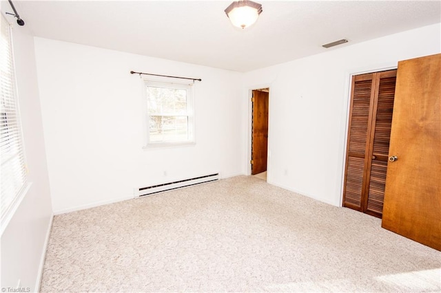 unfurnished bedroom featuring a baseboard radiator, carpet, and a closet