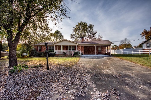 ranch-style home with a porch, a carport, and a front yard