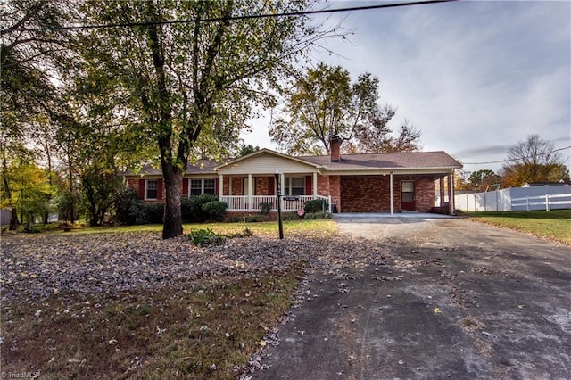 ranch-style home with a carport and covered porch