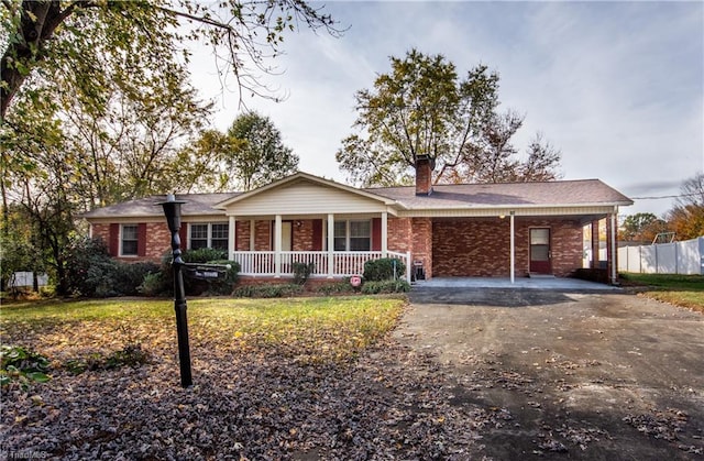 ranch-style home featuring a carport and covered porch