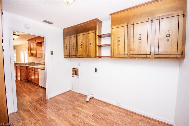 laundry room featuring sink, cabinets, hookup for a washing machine, hookup for an electric dryer, and light hardwood / wood-style floors