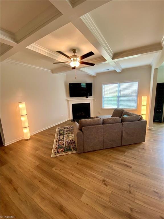 living room with ceiling fan, wood-type flooring, ornamental molding, and beamed ceiling