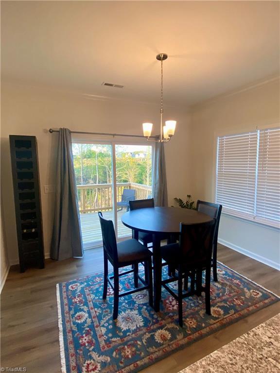 dining room with dark hardwood / wood-style flooring and a notable chandelier