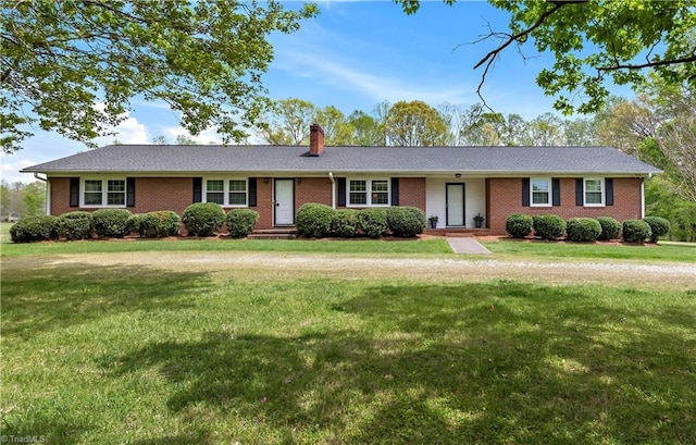 single story home with a front lawn, brick siding, and a chimney