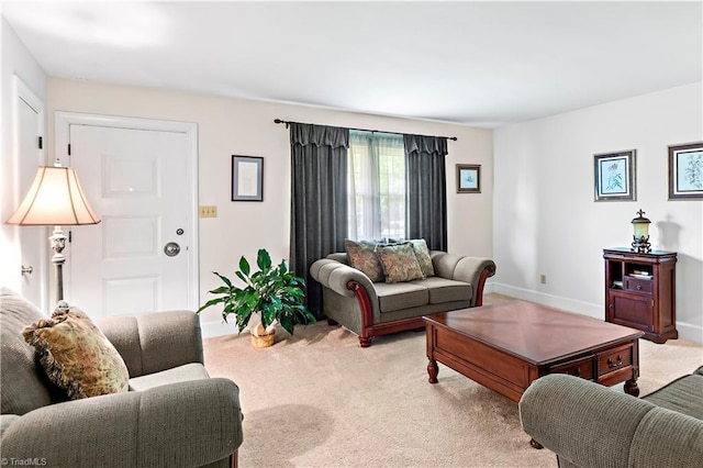 living area with baseboards and light carpet
