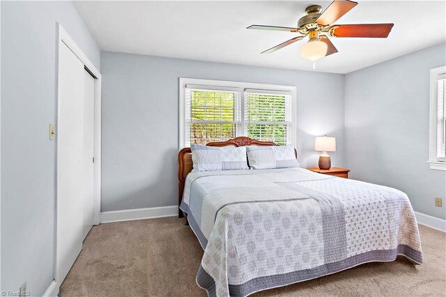 carpeted bedroom featuring baseboards, a ceiling fan, and a closet
