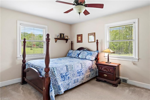 bedroom with baseboards, carpet flooring, multiple windows, and visible vents