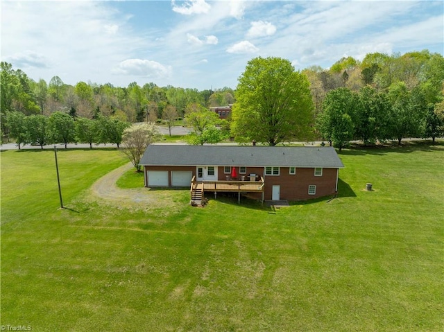 back of house featuring a wooden deck, a yard, dirt driveway, and an attached garage