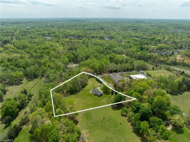 birds eye view of property featuring a wooded view