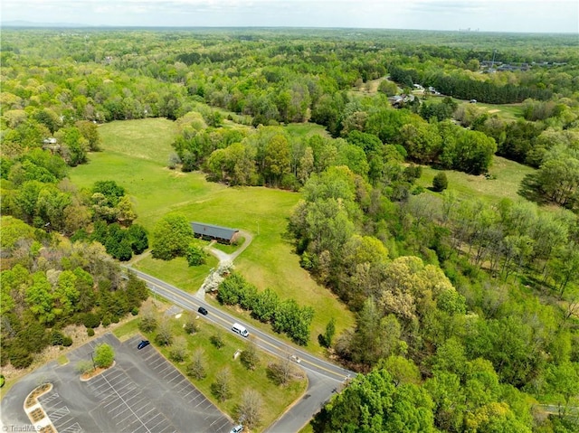 birds eye view of property featuring a forest view