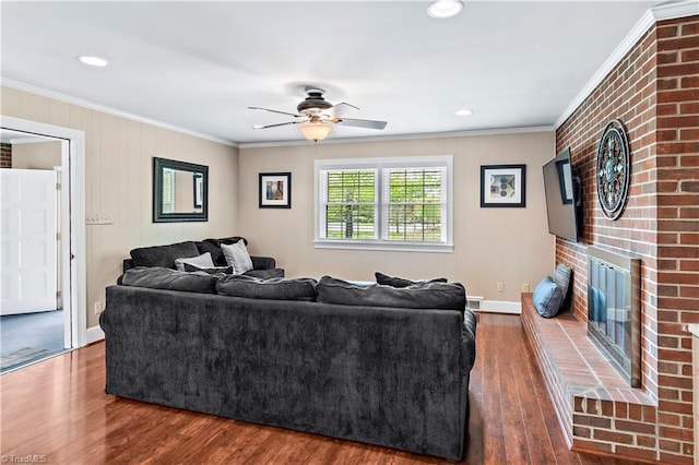 living area featuring a fireplace, wood finished floors, a ceiling fan, and ornamental molding