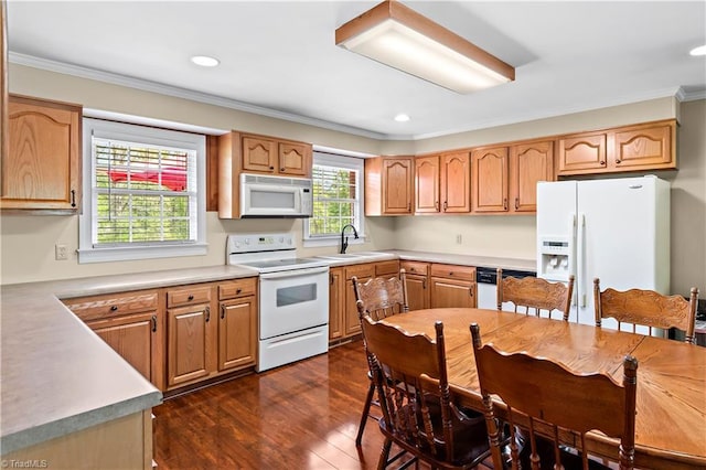 kitchen featuring crown molding, a sink, white appliances, light countertops, and dark wood-type flooring