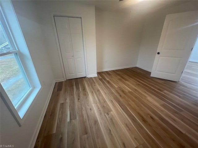 unfurnished bedroom featuring light hardwood / wood-style flooring and a closet