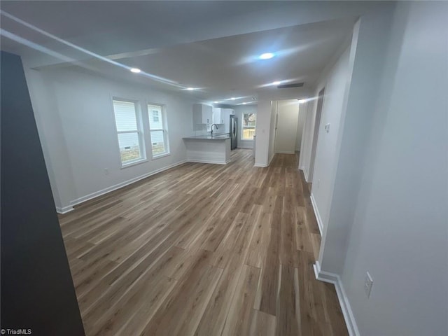 unfurnished living room featuring light hardwood / wood-style flooring and sink