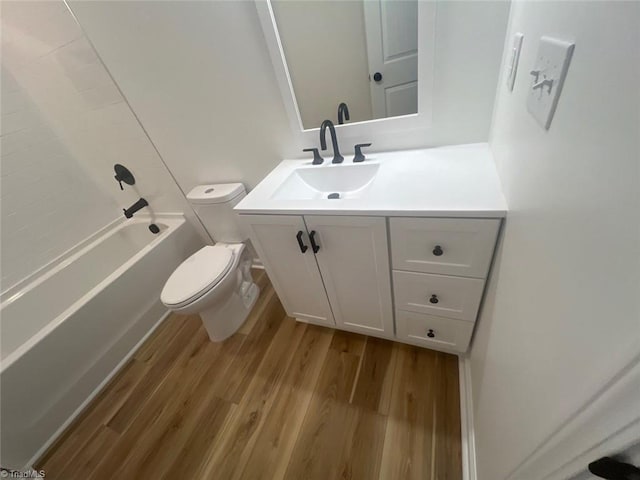 full bathroom with bathing tub / shower combination, vanity, wood-type flooring, and toilet