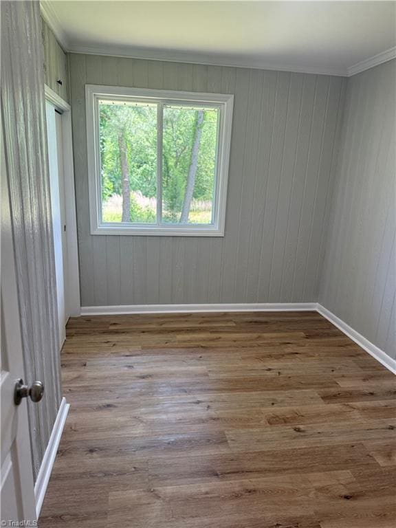4115 Rose Lake Dr, Greensboro, NC 27407 - empty room featuring wood finished floors, ornamental molding, baseboards, and wood walls