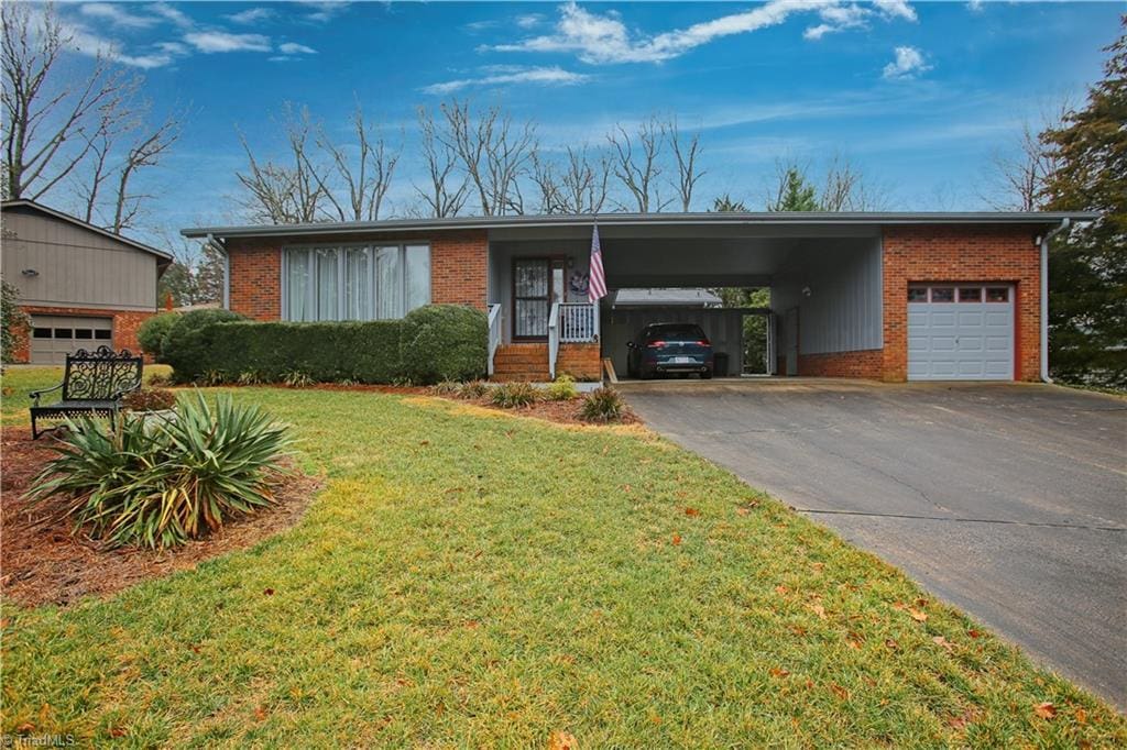 single story home with a carport, a garage, and a front yard