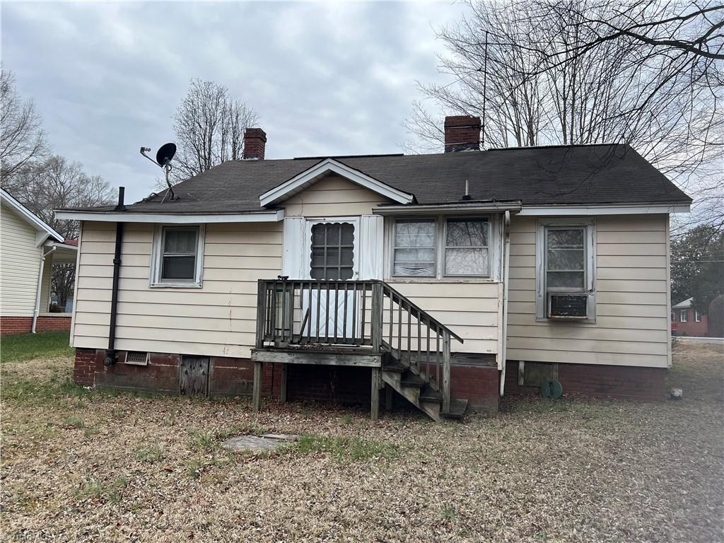 rear view of property featuring a chimney