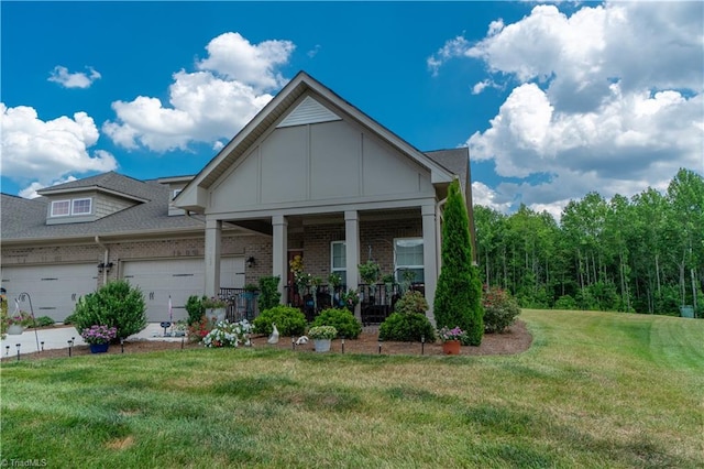 view of front of property with a garage, a front lawn, and covered porch