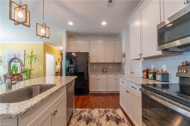 kitchen with stainless steel appliances, wood finished floors, a sink, ornamental molding, and pendant lighting