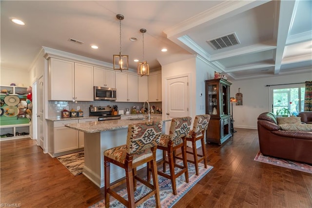 kitchen featuring appliances with stainless steel finishes, open floor plan, visible vents, and dark wood-type flooring