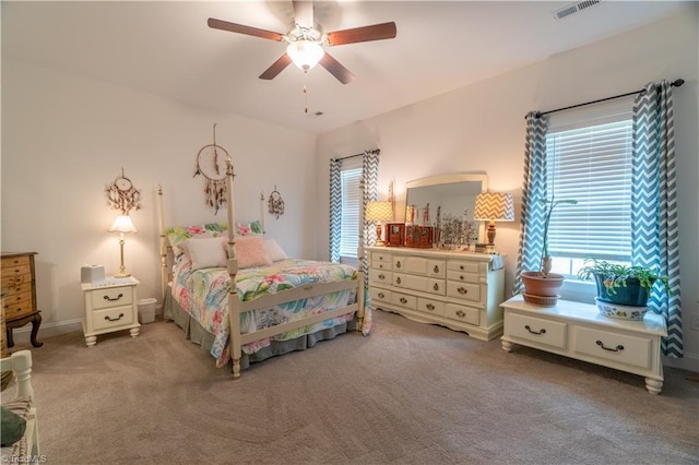 bedroom with visible vents, a ceiling fan, and light colored carpet