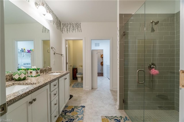 full bathroom with double vanity, a shower stall, visible vents, and a sink