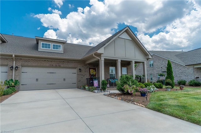 view of front of house featuring covered porch, a garage, brick siding, driveway, and board and batten siding