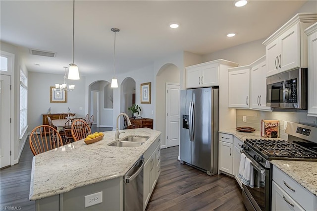 kitchen with arched walkways, a sink, visible vents, white cabinets, and appliances with stainless steel finishes