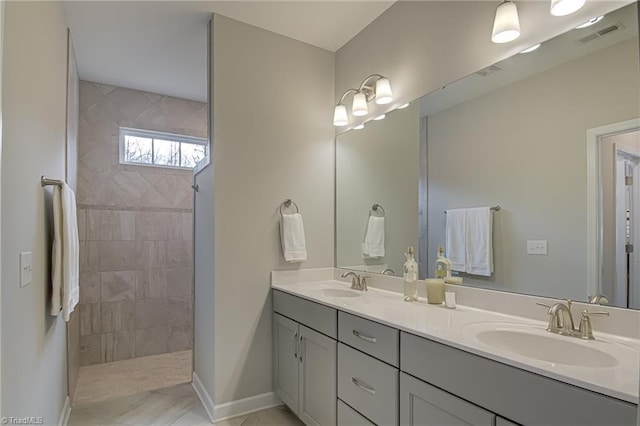 bathroom featuring double vanity, visible vents, a sink, and a walk in shower