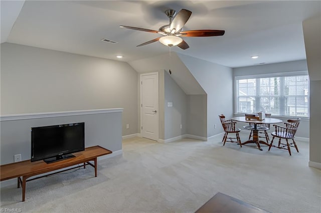 living area featuring light carpet, visible vents, baseboards, and lofted ceiling