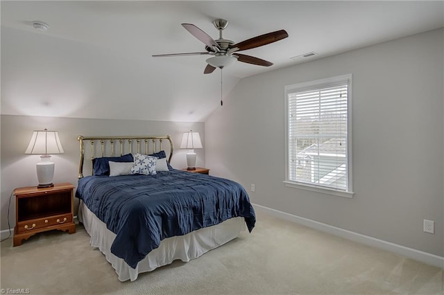 bedroom featuring light colored carpet, visible vents, a ceiling fan, vaulted ceiling, and baseboards