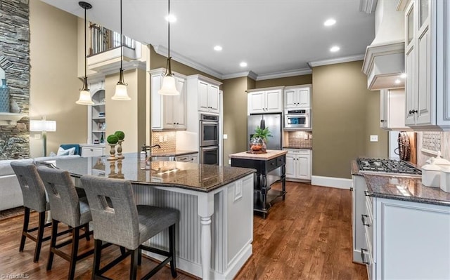 kitchen featuring dark stone counters, white cabinets, appliances with stainless steel finishes, and a sink