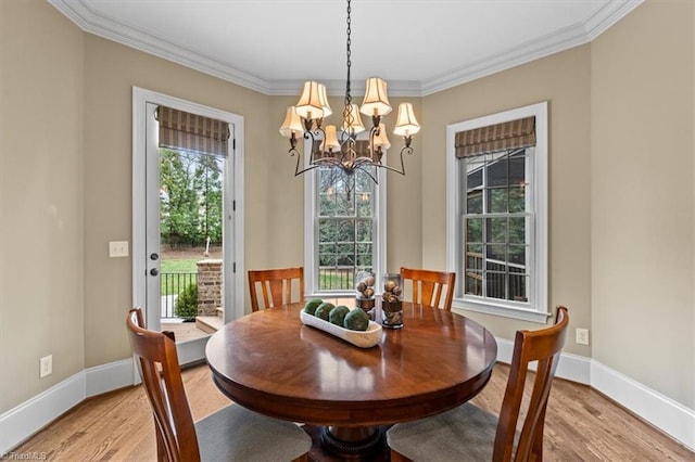 dining space with crown molding, light wood-type flooring, and baseboards