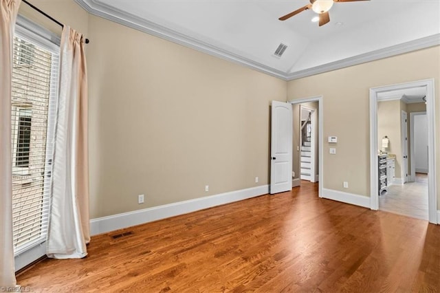 unfurnished bedroom featuring visible vents, wood finished floors, baseboards, and ornamental molding